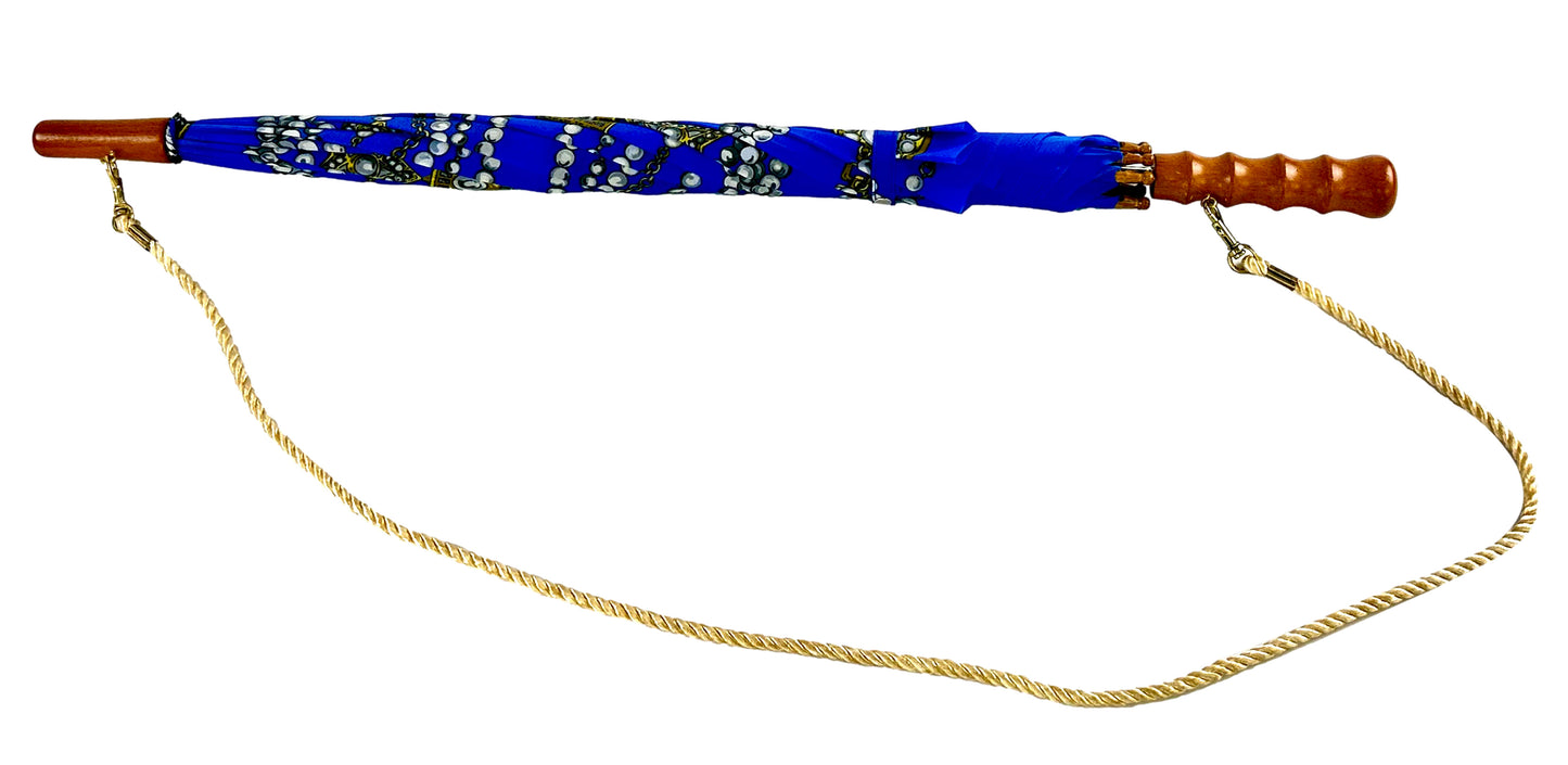 Εμπριμέ ομπρέλα, μακριά, αυτόματη, με ίσια ξύλινη λαβή και λουρί για τον ώμο.